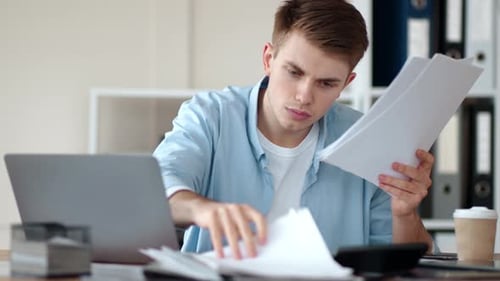 Worried Businessman Searching Important Documents on Worktable in Home Office