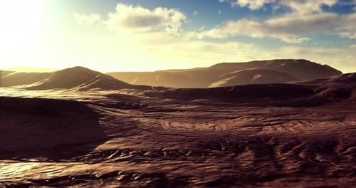 Weite Wüstenlandschaft, die in den frühen Morgenstunden in goldenes Sonnenlicht getaucht ist