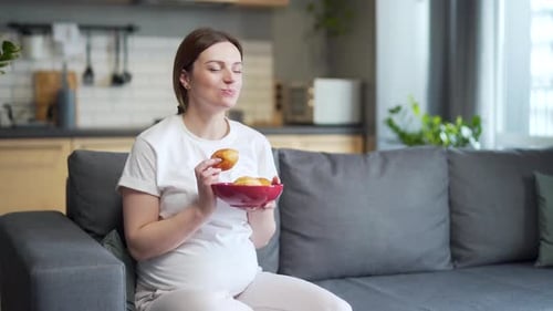 расстроенная беременная женщина смотрит на сладости