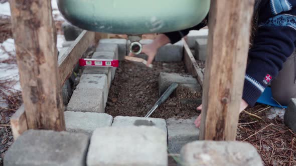 The Man is Compressing the Concrete Block and then Employing a Level to ...