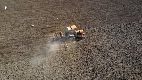Tracteur labourant les champs, préparation du terrain pour l'ensemencement, vue aérienne