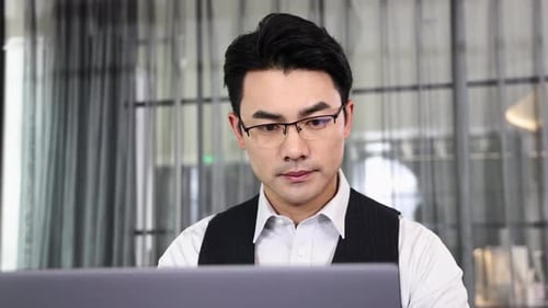 Portrait of confident male employee, staff member looking at laptop using computer working in office