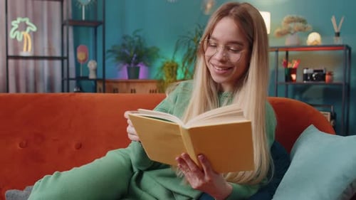 Woman Enjoys Reading Book While Relaxing on Couch