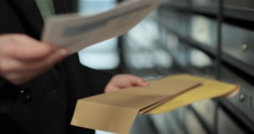 Close Up Woman is Opening Her Mailbox Inside a Cluster of Mailboxes for Her Apartment Payment