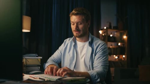 Man Typing at Computer Late at Night Indoors
