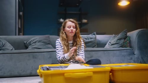 Woman Packing Yellow Suitcase in Living Room