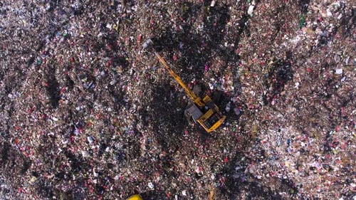 Aerial View of Excavator Moving Waste in Landfill