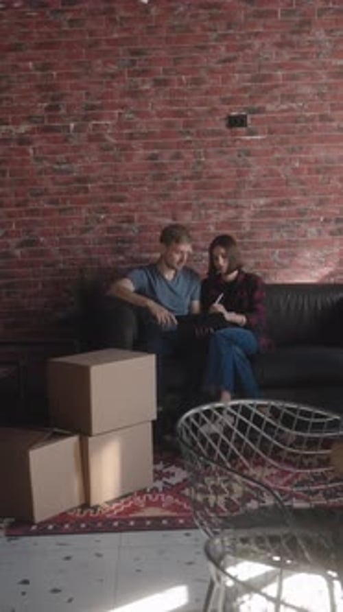 Young Couple Looks at Tablet in Apartment
