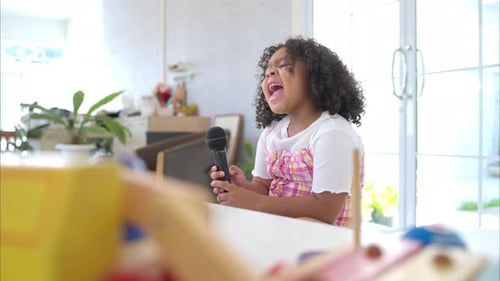 Young Girl Singing with Microphone at Home