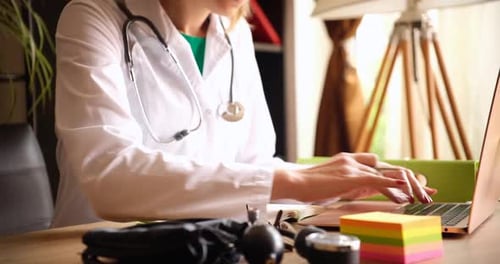 Une femme médecin saisit efficacement les notes des patients sur un ordinateur portable