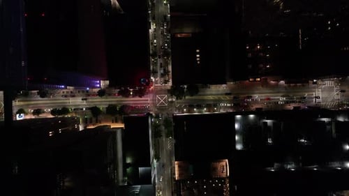 Aerial view of Road intersection with street lights and moving cars in American city at night, Downt