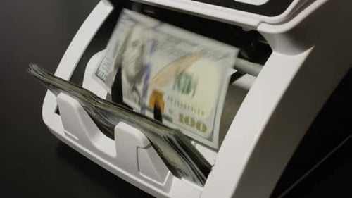 Money Counter Machine Counting Stacks of Hundred Dollar Bills