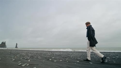A Young Man at Reynisfjara the Iconic Black Sand Beach in South Icelands Landscape