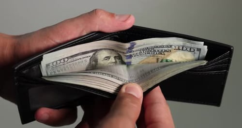 Hands Holding Wallet with Stack of Hundred Dollar Bills