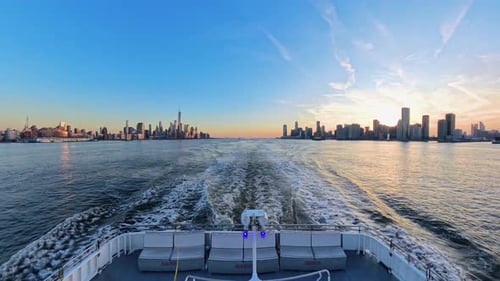 Ferry departing New York City with stunning skyline and sunset reflections, USA