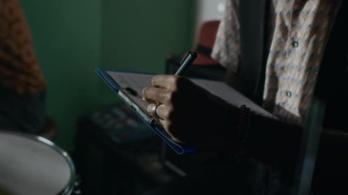 Unrecognisable African American Man Writing Sheet Music for New Song