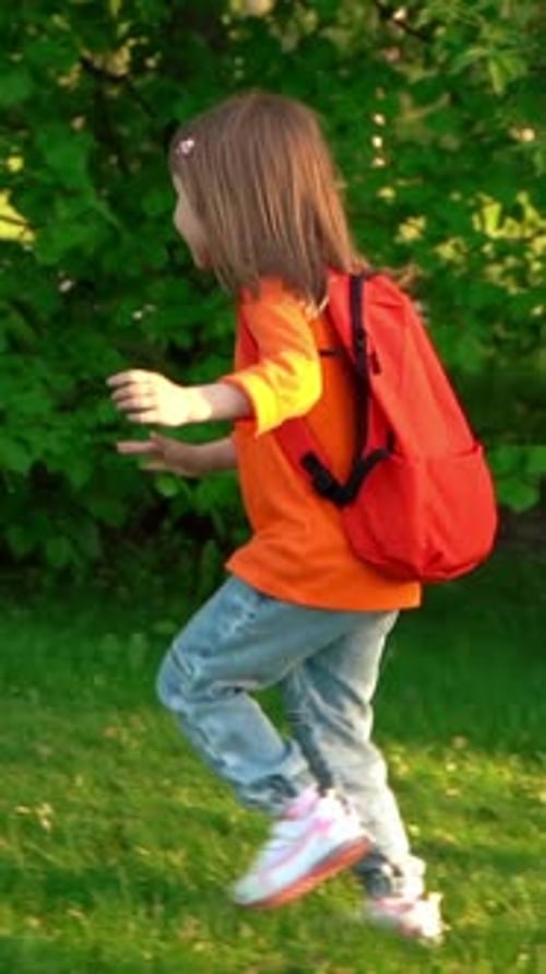 Girl with School Backpack Runs and Laughs in Summer Park Schoolchild
