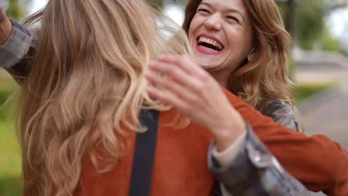 Joyful Woman Greeting Friend in Autumn Park Hugging in Slow Motion Smiling