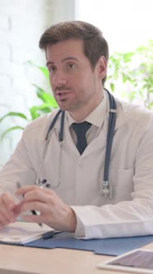 Focused Doctor Consults at Desk in Office