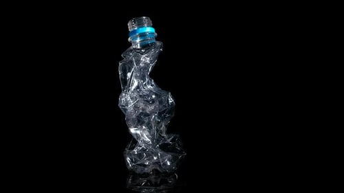 Crushed Plastic Bottle Rotating on Black Background