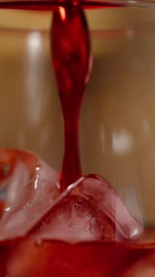 Red Liquid Pouring Over Ice Cubes