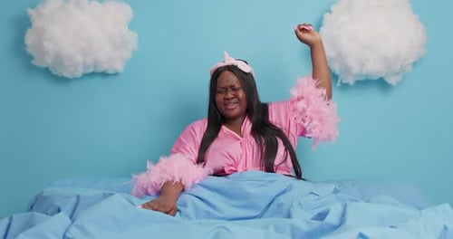 Tired Woman Yawns in Bed at Home