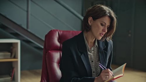Professional Female Psychologist Taking Notes on Therapy Session with Client