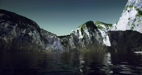 Rocky Cliffs Surrounding Calm Water Under a Clear Sky at Sunset