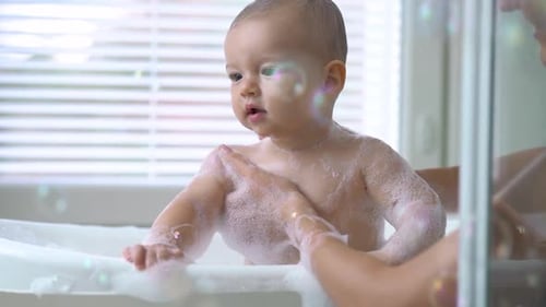 Happy Infant Taking a Bubble Bath at Home