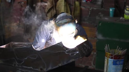 Person Welding Metal Object in Workshop