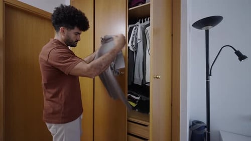 Man Choosing Clothes in Bedroom Closet