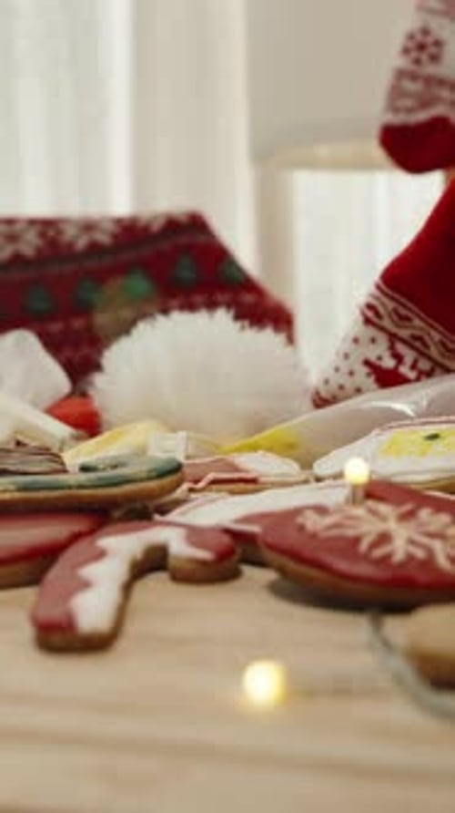 Vertical video. Decorated Christmas Cookies with Red Stockings, Mittens, and Tree in Holiday Setting