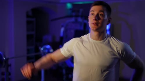 Portrait of Motivated Sportsman Stretching Hand Muscles Warming Up in Dark Gym Caucasian Man
