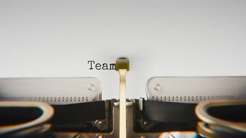 Old mechanical typewriter typing Teamwork Wins in a close-up view.