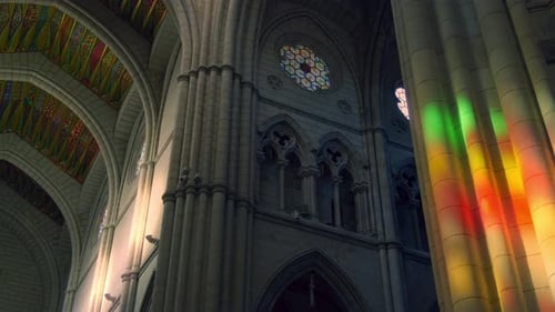 sunlight falls trough stained glass inside la almudena cathedral in madrid. slow camera movement