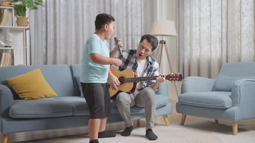 Boy Singing with Father Playing Guitar Inside