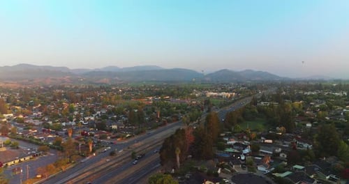 Roads full of cars in Napa, California, USA. Hot air balloons in the air over the city.