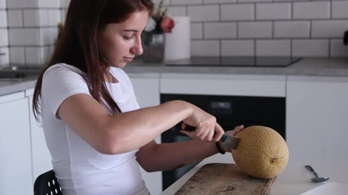 Fille coupant du melon