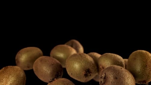 Kiwi Fruit Falling in Slow Motion on Black