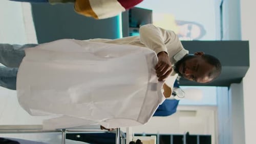 Man Browsing Clothing Racks in Retail Store