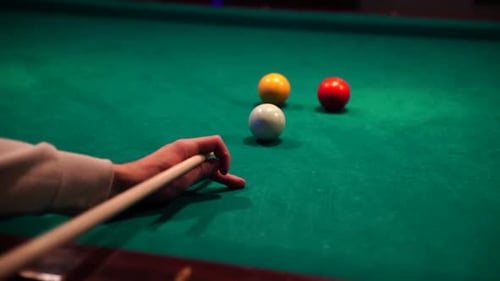 Sports game of billiards on a green cloth. Billiard balls with numbers on a pool table. Slow Motion
