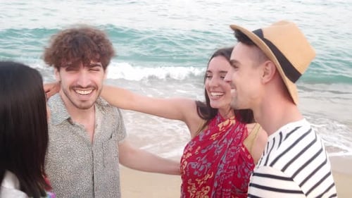 Group of Friends Hugging and Laughing on the Beach