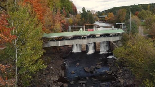 Drone shot flying over dam on river for hydropower energy generation