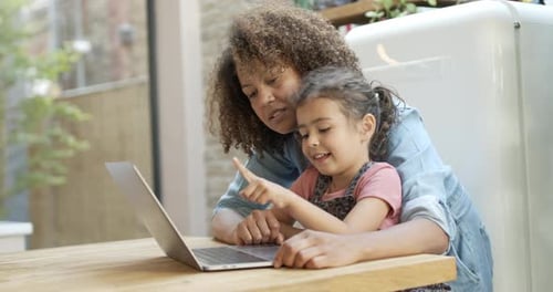 Woman and Child Smiling at Laptop