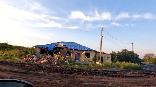Blick aus dem Auto auf die zerstörten Wohngebäude im Donbass, die nach Bombenangriffen zerstörten Häuser