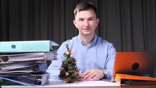 Office Worker with a Christmas Tree at his Desk
