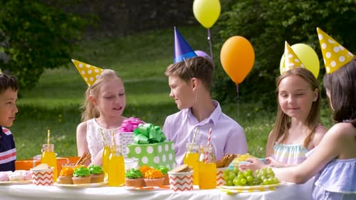 Children Celebrate Birthday at Party Outdoors With Gifts