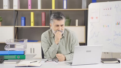 Man With Gray Hair Using Laptop in Office