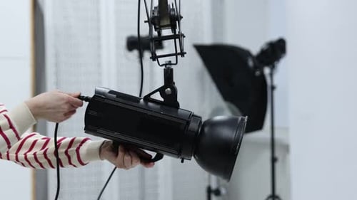 Woman with professional lighting equipment in photo studio, closeup