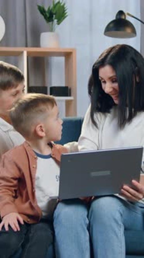 Family using tablet together sitting on couch at home